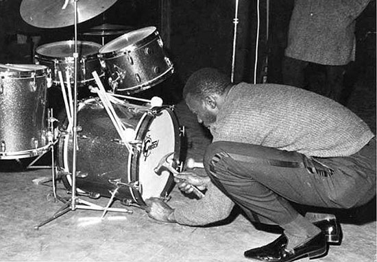 Elvin Jones fastgør sin storetromme med søm og hammer