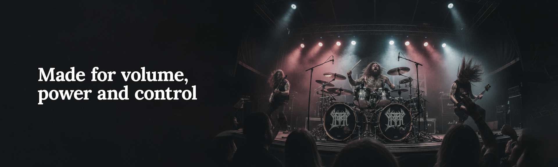 Audience at a live metal concert with hands raised in front of a lit stage