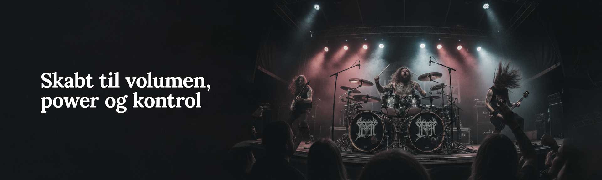 Publikum til live metal-koncert med hænder i vejret foran oplyst scene